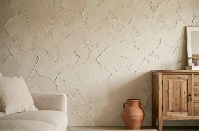 Mur texturé recouvert de peinture à la chaux avec variations de tons sable et blanc cassé dans un salon contemporain
